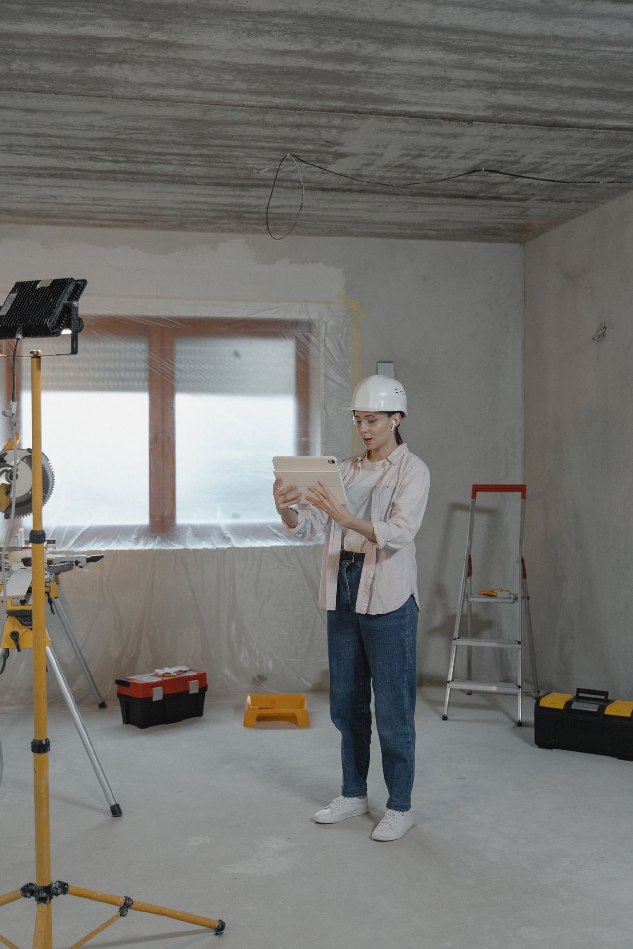 Bouwprofessional bekijkt een tablet op een renovatielocatie